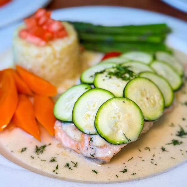 A Georgia Diner plate with salmon topped with zucchini, carrots, mashed potatoes, and asparagus.