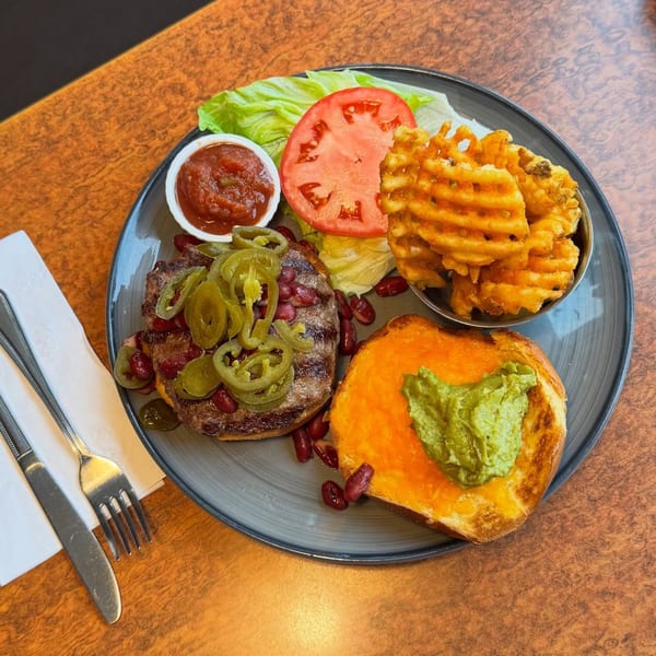 A Georgia Diner burger with jalapeños, kidney beans, waffle fries, and guacamole on a bun.